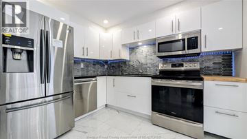Windsor condo for rent - A kitchen with white cabinets and stainless steel appliances.