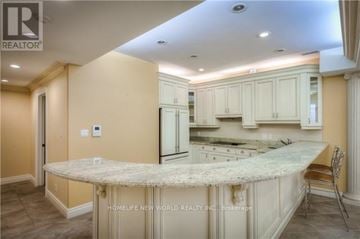 Toronto (Newtonbrook East) house for rent - A kitchen with a marble island and white cabinets.