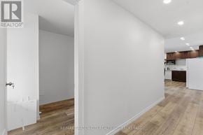 St. Catharines (Western Hill) duplex for rent - A white room with a door and a wooden floor.