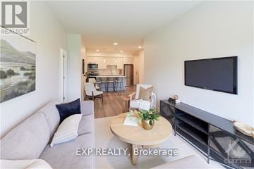 Ottawa condo for rent - A living room with a grey couch and a flat screen TV mounted on the wall.