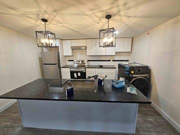 Poughkeepsie apartment for rent - A kitchen with a black countertop and a refrigerator.