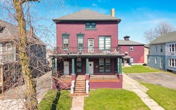 Buffalo apartment for rent - A red brick house with a green front porch.