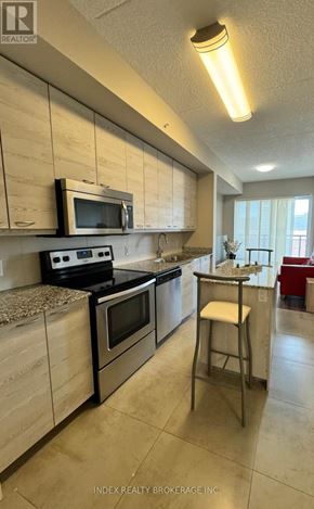 Waterloo condo for rent - A kitchen with a microwave, oven, and stove top.
