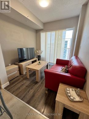 Waterloo condo for rent - A living room with a red couch and a wooden coffee table.