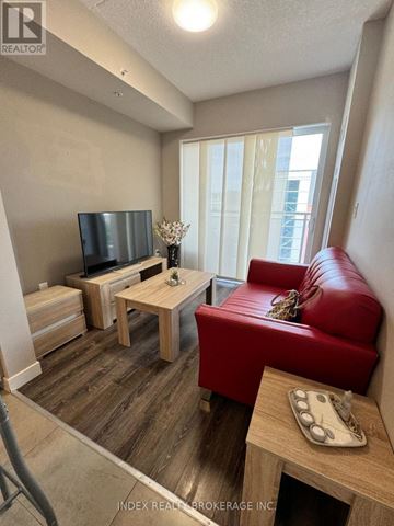 Waterloo condo for rent - A living room with a red couch and a wooden coffee table.