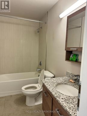 Waterloo condo for rent - A white toilet sits in a bathroom next to a sink.