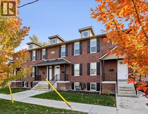 Windsor house for rent - A house with a red brick facade and a white door is surrounded by trees with orange leaves.