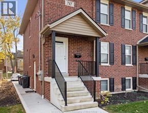 Windsor house for rent - A red brick house with a white door and black railings.