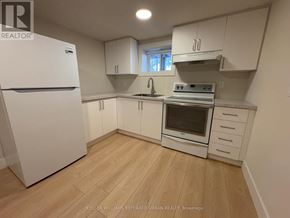 Toronto (Clanton Park) house for rent - A kitchen with white appliances and cabinets.