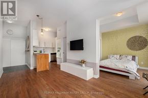 Ottawa condo for rent - A bedroom with a bed, a desk, and a TV in a modern style.