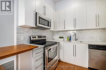 Ottawa condo for rent - A kitchen with white cabinets and a wooden counter top.