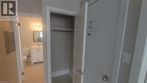 Kitchener apartment for rent - A bathroom with a toilet, sink, and a door leading to another room.