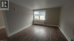 Kitchener apartment for rent - A room with wooden floors and a window with blinds.