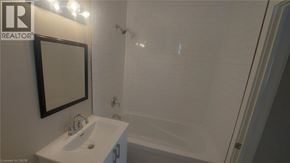 Kitchener apartment for rent - A white sink with a mirror above it in a bathroom.