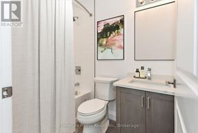 For rent in North Dumfries - A bathroom with a toilet, sink, and a painting on the wall.