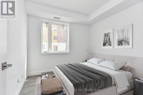 For rent in North Dumfries - A bedroom with a bed, nightstand, and two pictures on the wall.