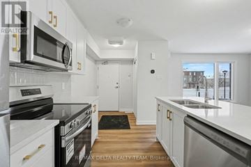 Ottawa townhouse for rent - A kitchen with white cabinets and stainless steel appliances.