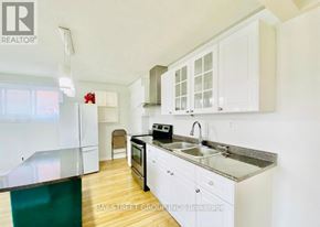 Oshawa (Vanier) house for rent - A kitchen with white cabinets and a black stove top oven.
