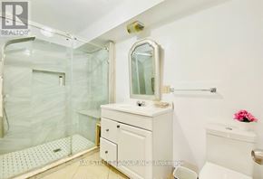 Oshawa (Vanier) house for rent - A white bathroom with a glass shower door and a white sink vanity.