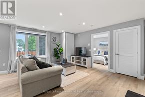 North Huron (Wingham) multi-family for rent - A well-lit, spacious living room with a couch, television, and a bed in the background.