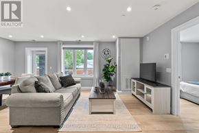 North Huron (Wingham) multi-family for rent - A living room with a grey couch, a wooden coffee table, and a flat screen TV.