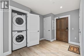 North Huron (Wingham) multi-family for rent - A laundry room with a washer and dryer stacked on top of each other.