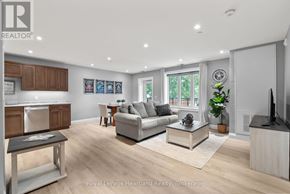 North Huron (Wingham) multi-family for rent - A well-lit living room with a kitchen area in the background.