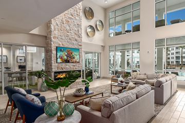 Apopka apartment for rent - A living room with a stone fireplace and a painting above it.