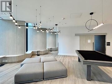 Toronto (Clanton Park) condo for rent - A modern living room with a pool table and a long couch.
