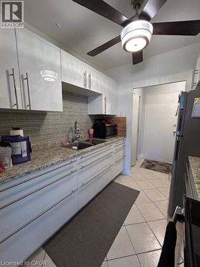 Hamilton apartment for rent - A kitchen with white cabinets and a ceiling fan.
