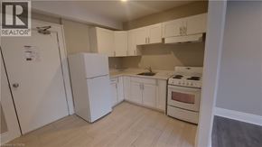Kitchener apartment for rent - A kitchen with white cabinets and a stove top oven.
