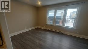 Kitchener apartment for rent - A room with a window and a wooden floor.
