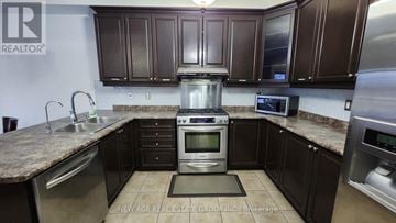 Brampton (Bram West) house for rent - A kitchen with brown cabinets and a granite countertop.