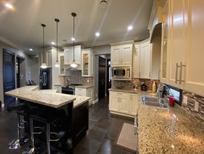 Surrey house for rent - A kitchen with granite countertops and a bar area.
