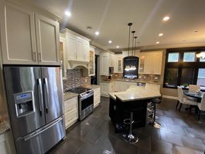Surrey house for rent - A modern kitchen with a stainless steel refrigerator and a central island with a bar stool.