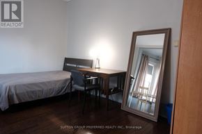 London East (East B) house for rent - A bedroom with a bed, desk, chair and mirror.
