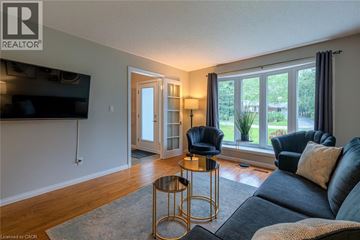 Ancaster house for rent - A living room with a grey couch and a black chair.