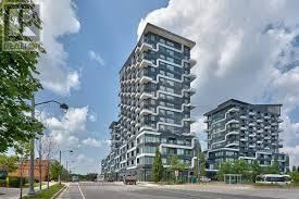 Oakville (Ro River Oaks) condo for rent - A modern multi-story building with balconies is situated on a street corner.