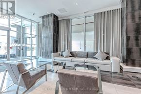 Oakville (Ro River Oaks) condo for rent - A modern living room with a glass wall and a grey sofa.