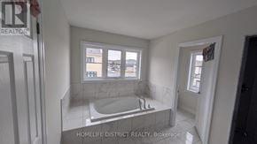 Clarington (Newcastle) duplex for rent - A bathroom with a tub and a window.