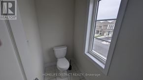 Clarington (Newcastle) duplex for rent - A bathroom with a toilet and a window overlooking a street.