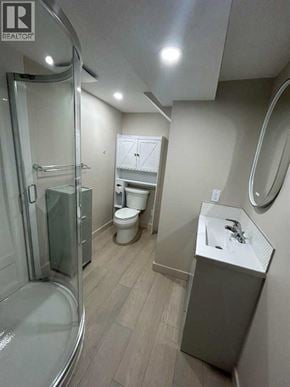 For rent in Calgary - A bathroom with a toilet, sink, and shower.