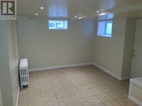 Toronto (Weston) triplex for rent - A room with a white radiator and tiled floor.