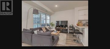 Toronto (Mimico) condo for rent - A living room with a grey couch and a television.
