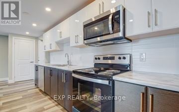 Mississauga (Cooksville) multi-family for rent - A modern kitchen with white cabinets and a stainless steel oven.