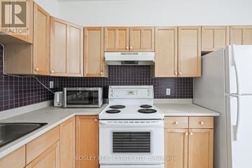 Toronto (Trinity-Bellwoods) other for rent - A kitchen with wooden cabinets and a white stove top oven.