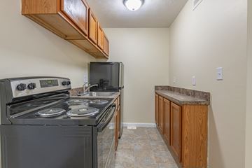 Dayton apartment for rent - A kitchen with a black stove top oven and a black microwave.