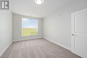 Tillsonburg multi-family for rent - A white bedroom with a window and carpeted floor.