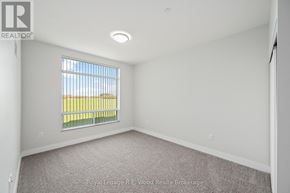 Tillsonburg multi-family for rent - A room with a window showing a yellow field outside.