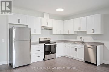 Tillsonburg multi-family for rent - A kitchen with white cabinets and stainless steel appliances.